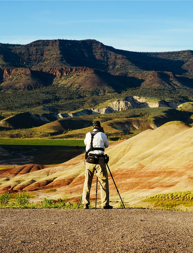 Person surveying a mountainous, semi-arid landscape