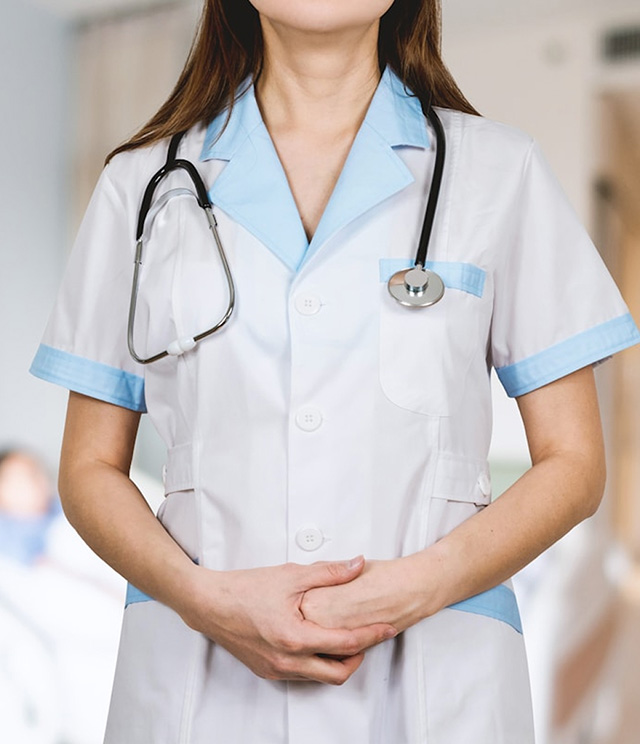 Close-up of a woman in white medical scrubs wearing a stethoscope around her neck