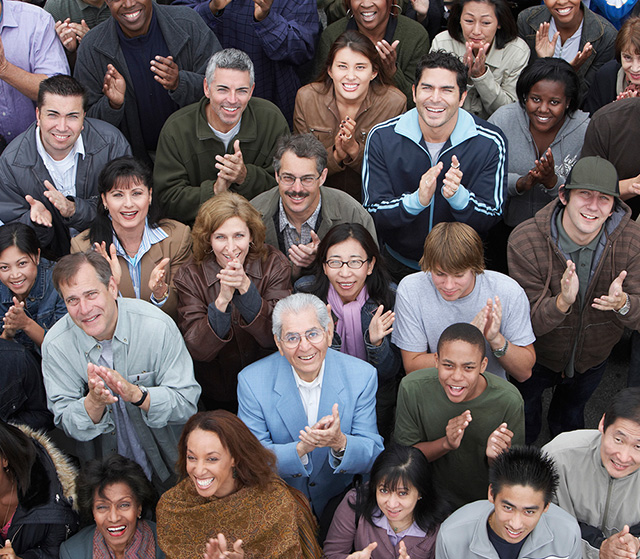 Crowd up people looking up towards the camera, clapping