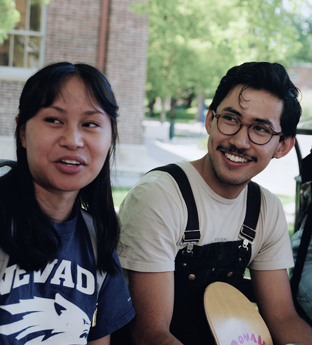 Two seated people smiling