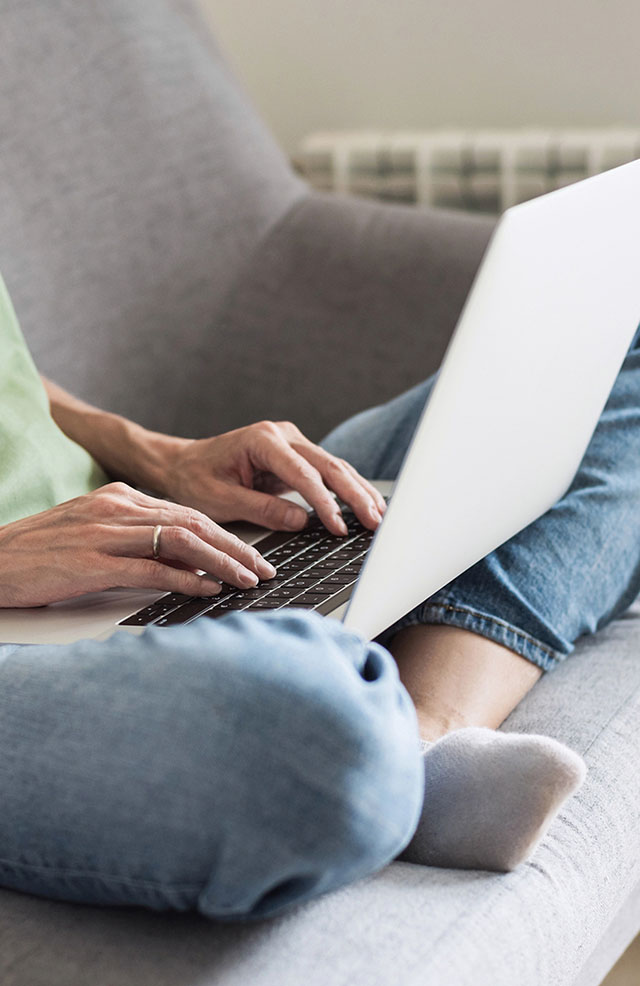 Closeup of a person's lap, typing on a laptop