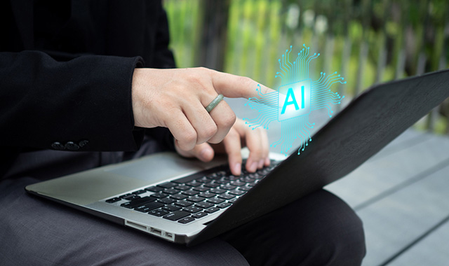 A person pointing at a glowing, holographic "AI" microprocessor icon rising from a laptop keyboard.
