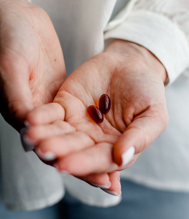 Outstretched hand holding two pills