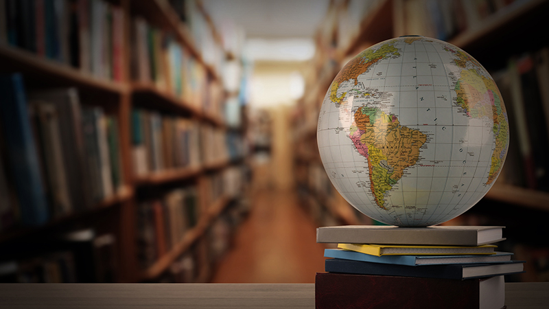 Globe sitting on a stack of books in a library