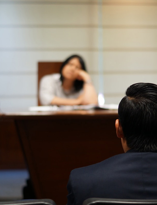 Person seen from behind facing an interviewer